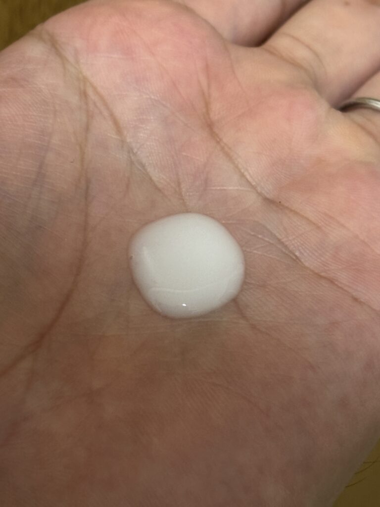 手のひらに出したエルジューダ エマルジョンの白い乳液状テクスチャー